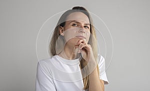 Puzzled perplexed young woman with distrustful face isolated on grey studio wall, unbelieving suspicious girl looking at camera