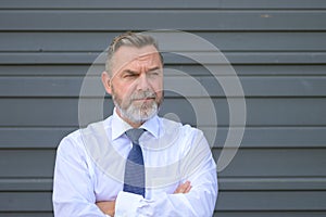 Puzzled senior businessman looking aside with a frown