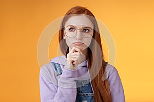 Puzzled serious-looking smart young redhead girl confused thinking deep focus problem touch chin frowning look upper