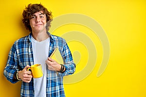 Puzzled student with book and cup of tea isolated