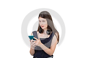 Puzzled young woman with headphones looking confused at her smartphone, isolated on white background