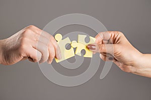 Puzzles. Man and woman holds in hand a jigsaw puzzle. Business solutions, success and strategy concept. Hands connecting