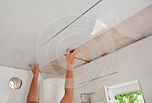 PVC Ceiling Panels, Cladding Installation. Builder installing, renovate, repair white PVC Ceiling Boards in the bathroom