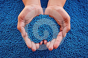 PVC granulate in hands, recycled plastic granules, biodegradable plastic. Granules of eco-friendly plastic raw material