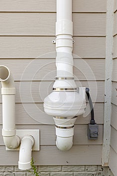 PVC pipes attached to the electrical motor of a residential radon mitigation system.