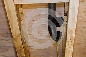 PVC plastic toilet sewer drain pipe in the plumber gluing, on wooden frame beam of house