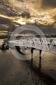 Pwllheli marina, walkway gantry access to boats, in late evening sunlight. photo