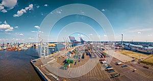 Aerial view of a container terminal in the port of hamburg by sunshine with many clouds