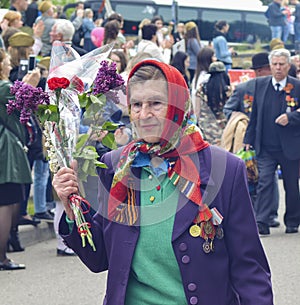 PYATIGORSK, RUSSIA - MAY 09, 2017: War veteran woman with flowers on the Victory Day celebration