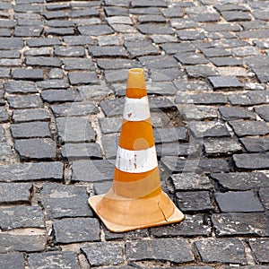 Pylon on a cobblestone, limitation and restraint on the road