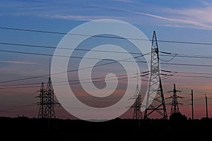 Pylon high voltage power line on sunset. Large towers of metal structures with electric wires on the sunset background.