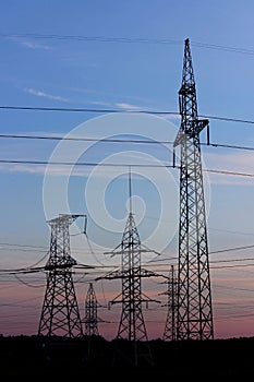 Pylon high voltage power line on sunset. Large towers of metal structures with electric wires on the sunset background.