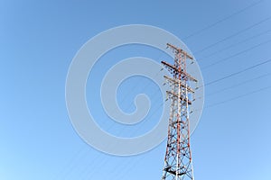 Pylon and transmission power line in front of sky.