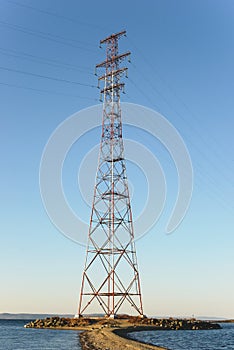 Pylon and transmission power line in front of sky.