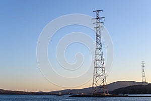 Pylon and transmission power line in front of sky.