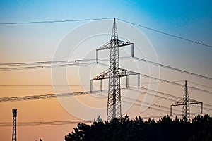 Pylon and transmission power line in sunset