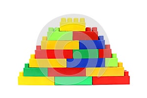 Pyramid assembled from the details of a multicolored bright constructor on a white isolated background