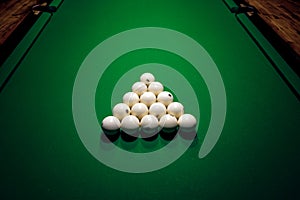 Pyramid of billiard balls on a green canvas