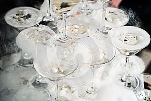 Pyramid with champagne glasses with steam of dry ice.