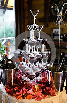 Pyramid of champagne with rose petals at a party or wedding