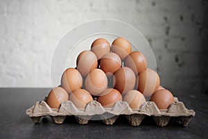 Pyramid of chicken eggs on a white wall background