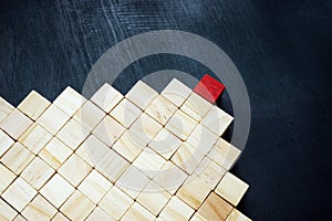 Pyramid of cubes and red as the leader. Leadership development concept.