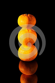 Pyramid of fresh tangerines on a black background