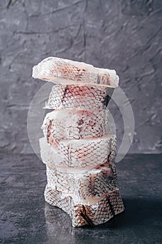 Pyramid of freshly frozen Macrourus fish. Gray background