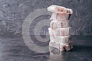 Pyramid of freshly frozen Macrourus fish. Gray background