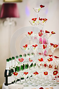Pyramid glasses of champagne with olives and rose petals