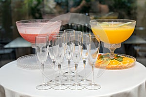 A pyramid of glasses. Orange and pink Champagne with fruits.