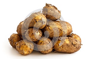 Pyramid heap of unwashed new potatoes isolated on white. photo