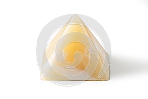 Pyramid made from yellow onyx possesses mystical properties. Souvenir semiprecious stone on a white background