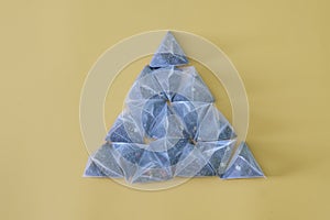 Pyramid of many tea bags-pyramids with black and green tea, with pieces of fruit, on a yellow background. Pyramid shape. Healthy