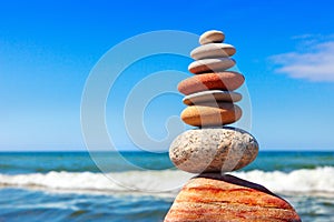 Pyramid of multicolored pebbles on a background of the summer sea.