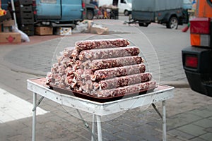 Pyramid of natural homemade sausages on the counter of the village market. Natural food