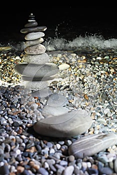Pyramid from pebble on seacoast at night