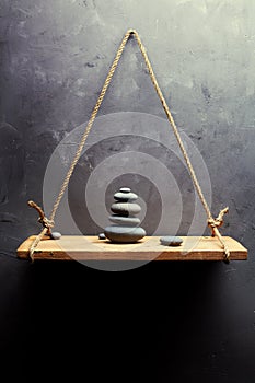 Pyramid of pebbles on the old wood shelf