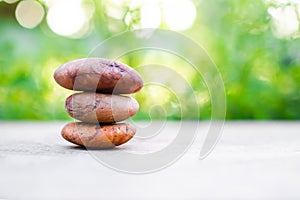 Pyramid pebbles on wood outdoor nature blur bokeh background. stack old zen stone for stability, equilibrium, calm, meditation,