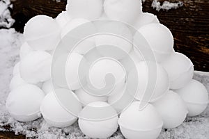 pyramid or a pile of perfect snowballs on frosty winter day in forest or garden outdoor.