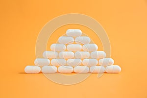 Pyramid of pills on an orange background