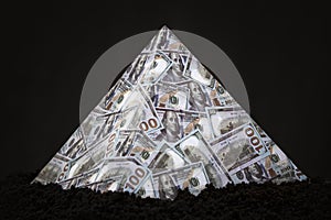 a pyramid scheme on black background. The concept of financial fraud. The dollar as a global financial pyramid