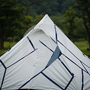 A pyramid-shaped tent with a modern design features angular blue geometric patterns