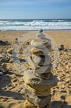 Pyramid from stack balanced stones on sandy beach, Atlantic ocean, Portugal