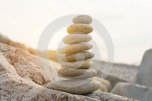 Pyramid stones balance on the beach in the sun.