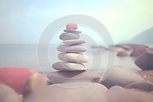 Pyramid stones balance on the sand of the beach. The object is in focus, the background is blurred. Neural network AI