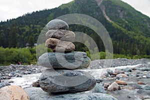 Pyramid of stones on the bank of a mountain river. Balance, relaxation symbol, zen meditation