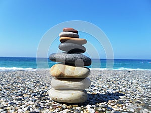 Pyramid of stones on the beach against the sea and sky