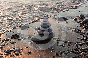 Pyramid of stones on the beach at sunset