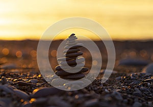 Pyramid of Stones on the Beach at Sunset, Beautiful Seascape, Seaside vacation concept, Panoramic Background, Balance